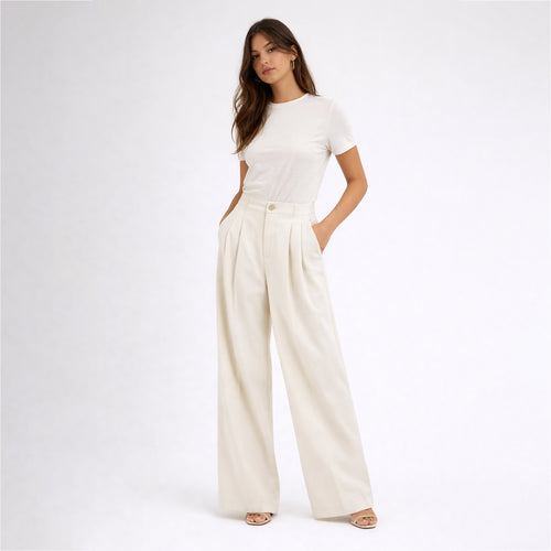 Woman wearing a white t-shirt and cream-colored wide-leg pants on a white background